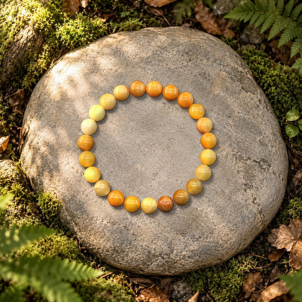 Bracelet jade jaune Halo en perles naturelles posé sur une pierre en forêt