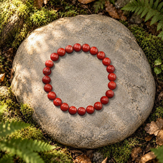 Bracelet jaspe rouge Halo en perles naturelles posé sur une pierre en forêt