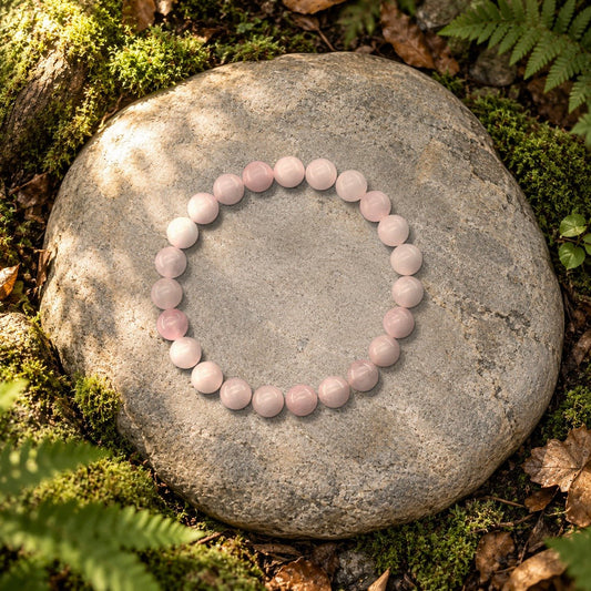 Bracelet quartz rose Halo en perles naturelles posé sur une pierre en forêt