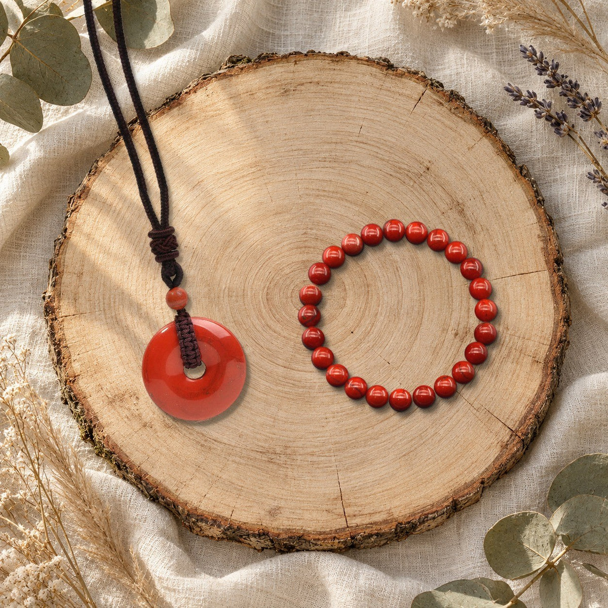 Duo collier Nuée et bracelet Halo en jaspe rouge sur une tranche de bois